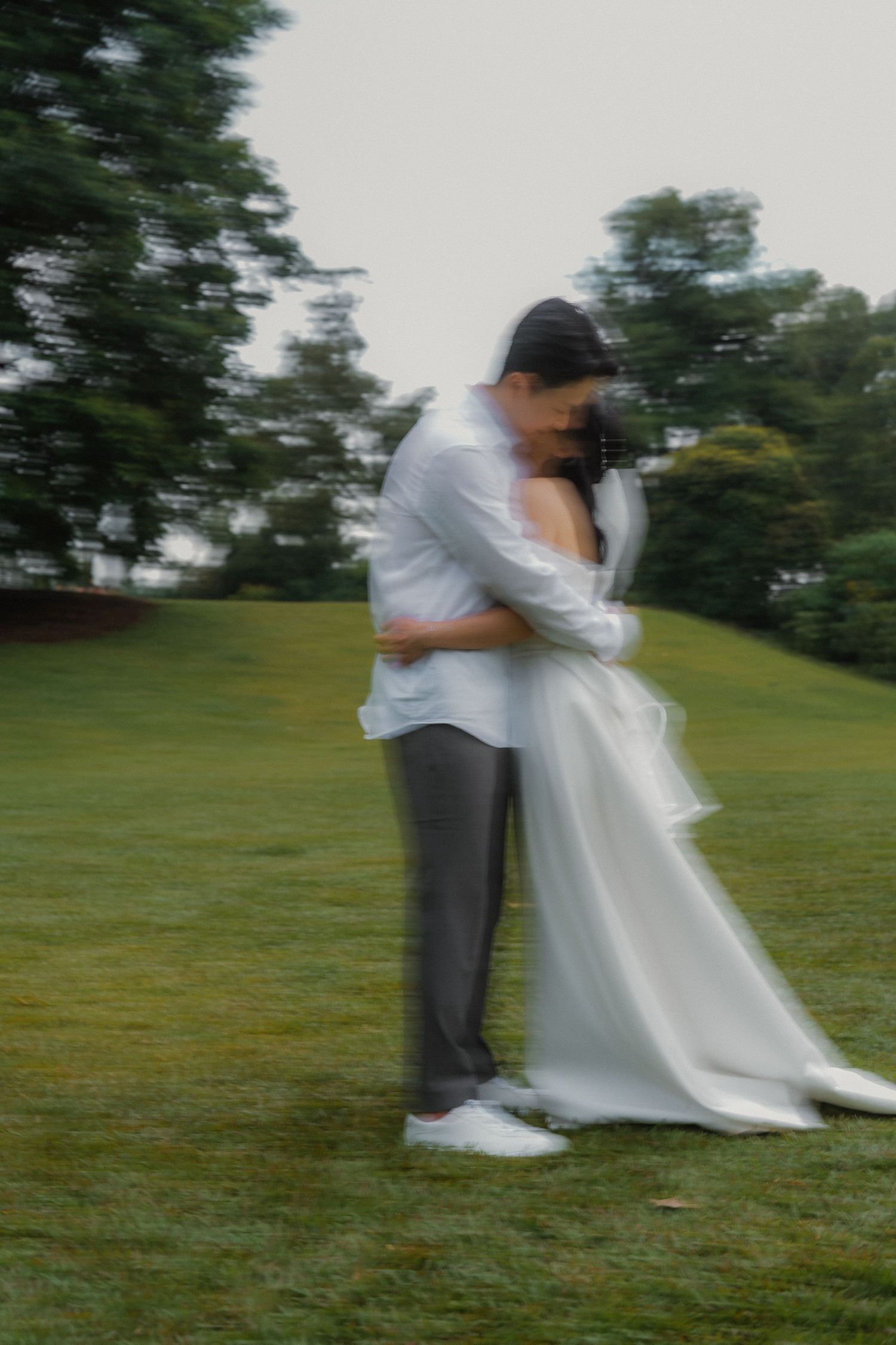 An artistic blurred photo of an intimate embrace on a misty lawn.