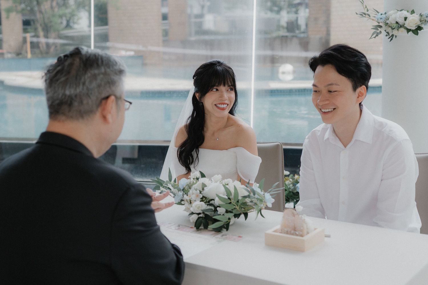 Elegant wedding reception table setup with happy guests engaged in conversation in a bright indoor space.
