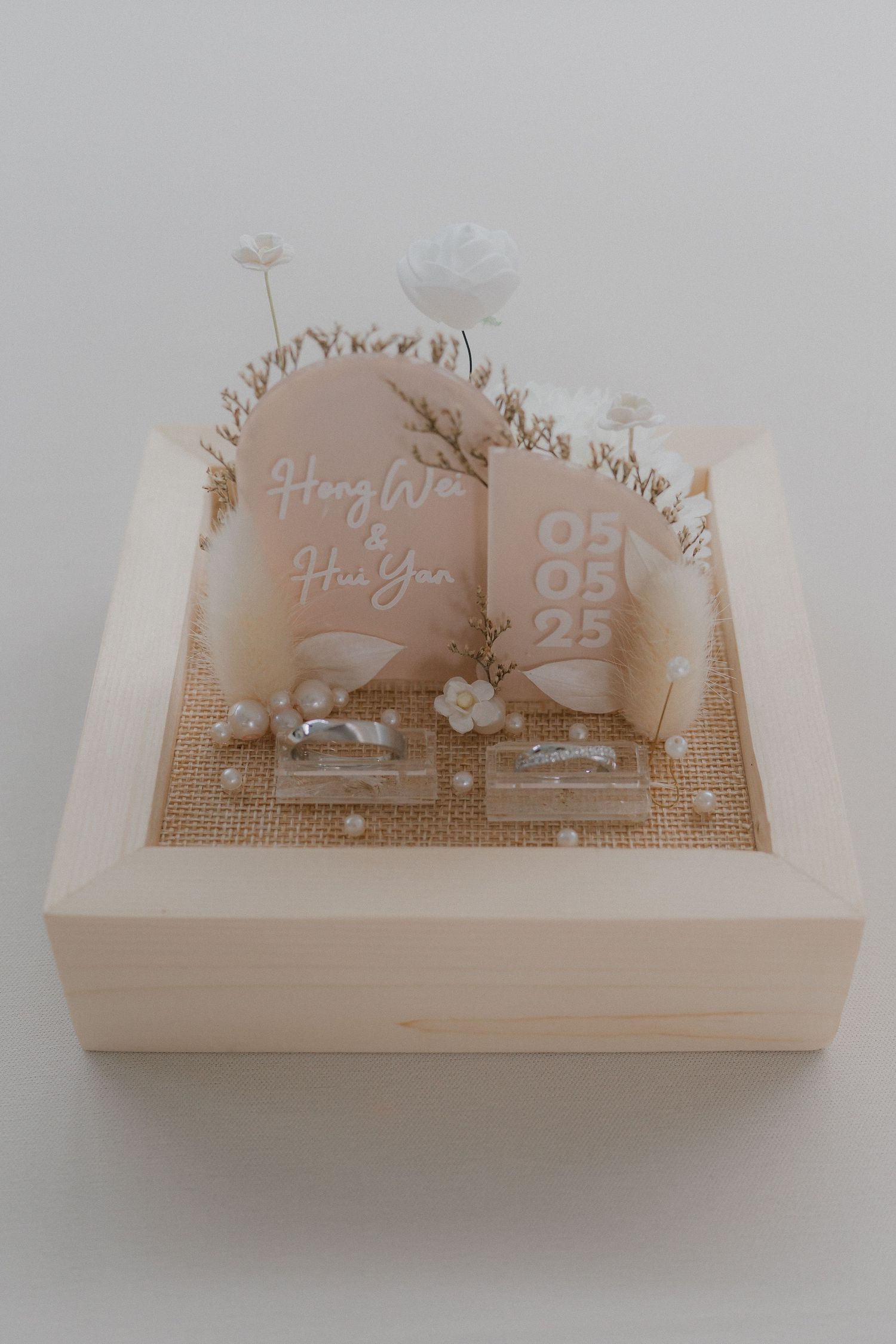A decorative book-shaped display box with delicate floral designs and text on a light beige background.