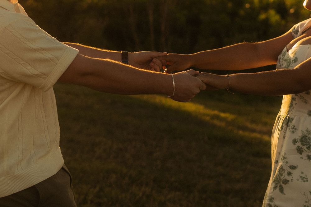 m/f couple close up of their hands playing ring around the rosie