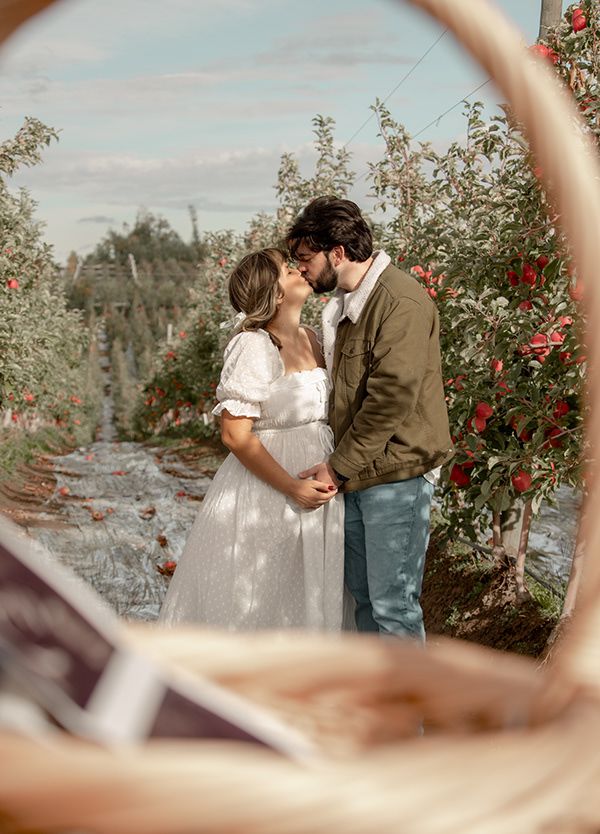Maternity photo of couple kissing in an apple orchard in Eastern WA