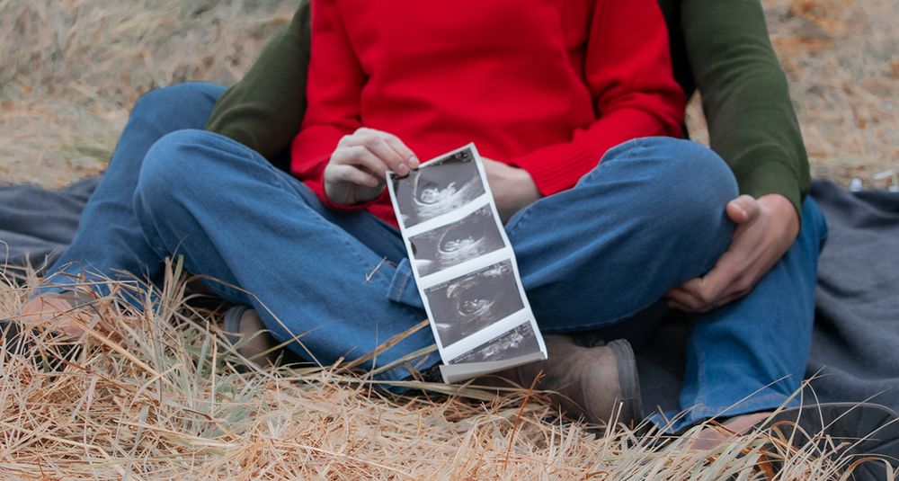 Close-up of sonogram resting on expectant parent’s lap during fall pregnancy announcement in Tri-Cities WA