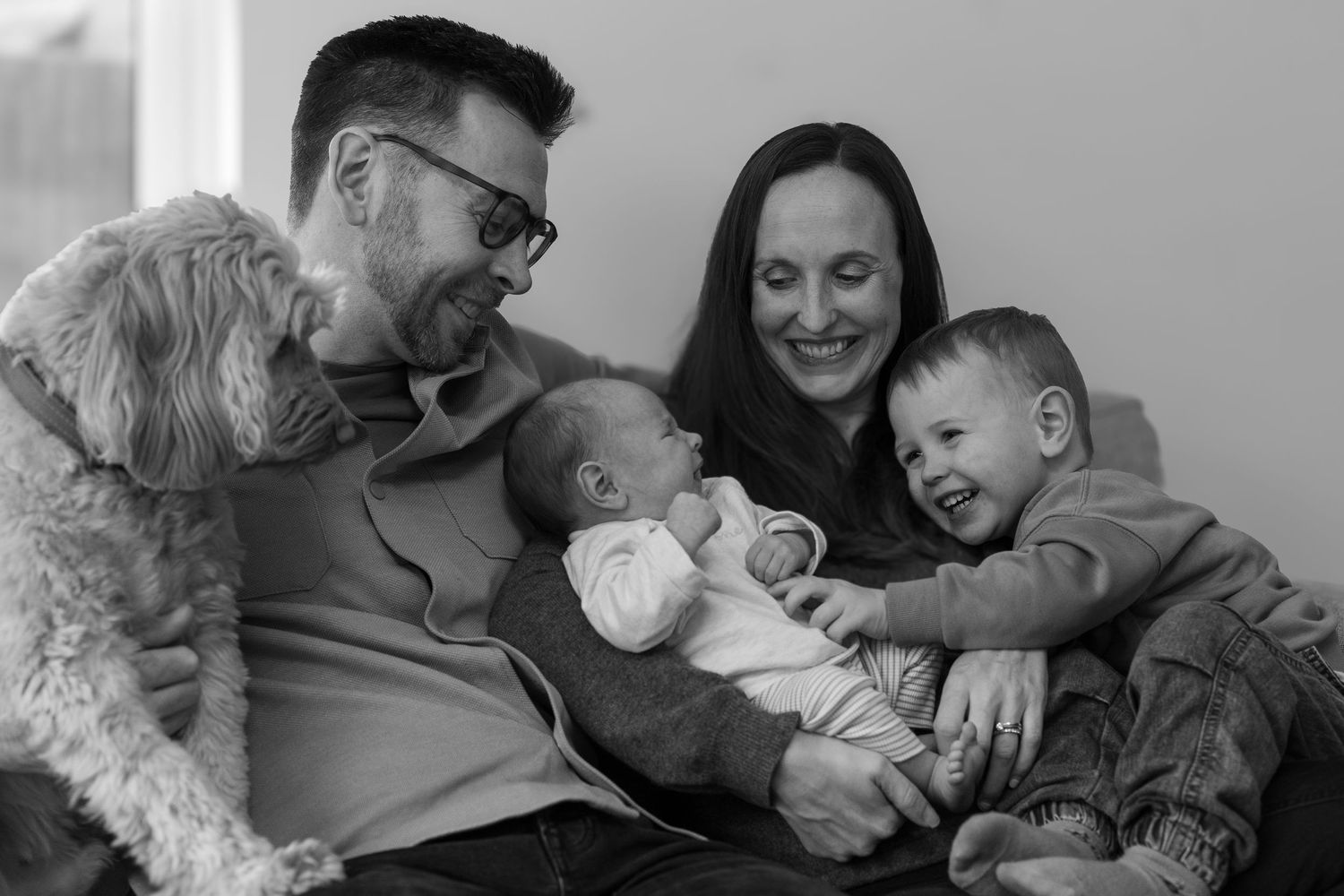 A heartwarming montage of black and white photographs showing tender family moments and interactions with newborns.