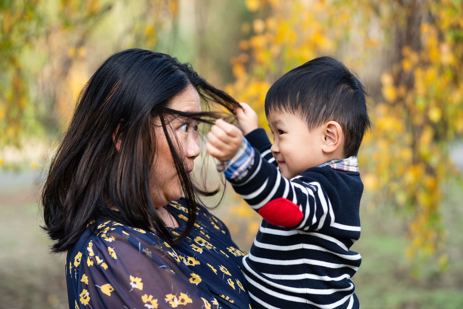 Boy playing with moms hair.