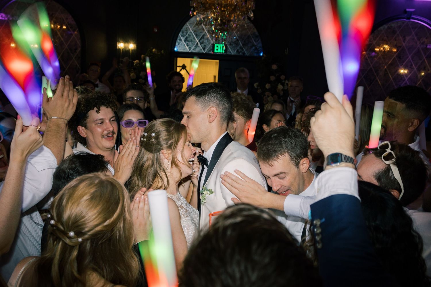 People dancing and enjoying themselves at a nightclub under colorful disco lights and party atmosphere.