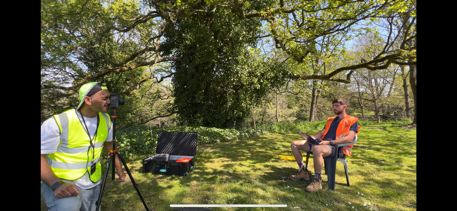 A diverse team conducting an outdoor survey with measuring equipment and tools in a green park setting.