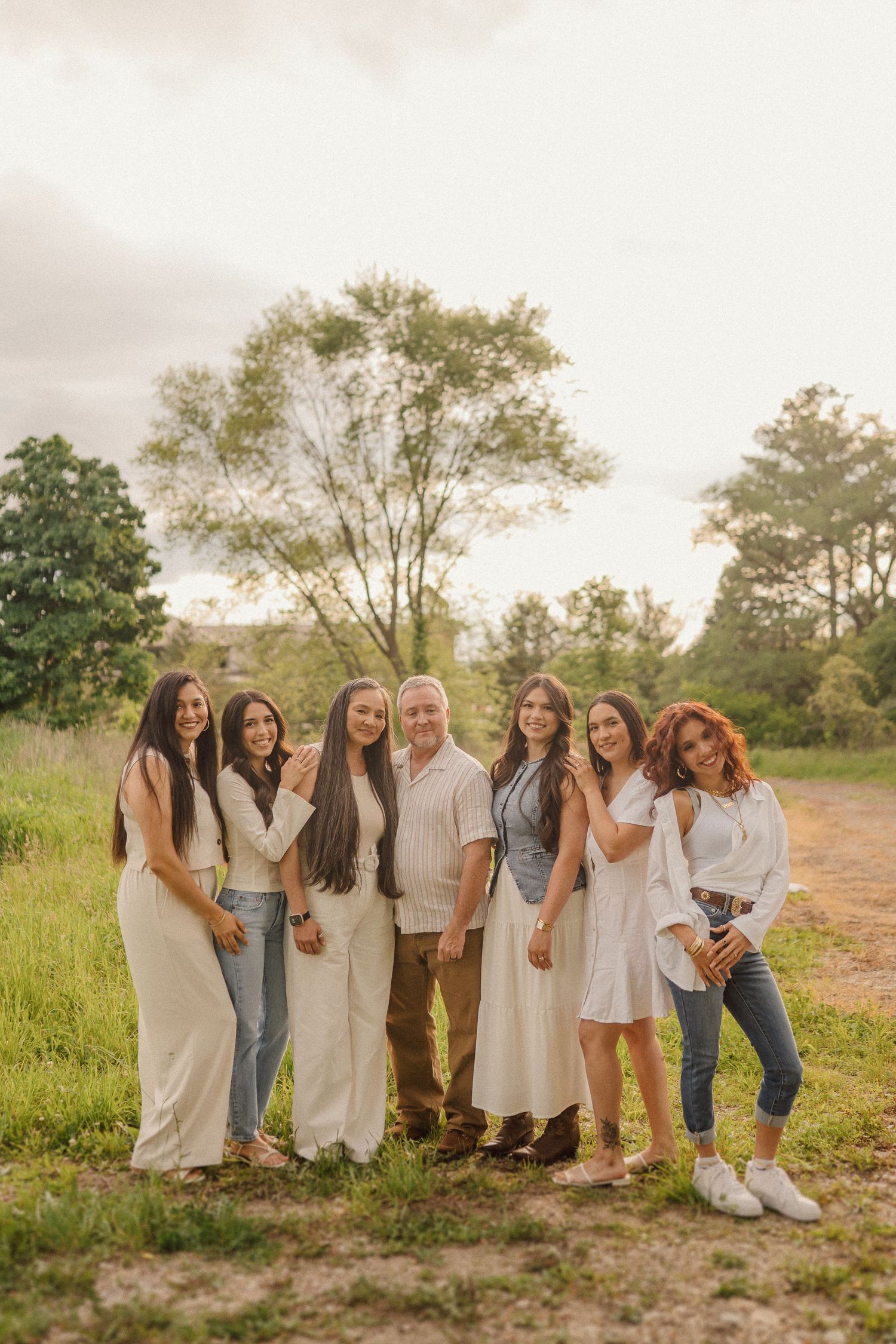 Group of friends posing together on a countryside path during a warm autumn evening.
