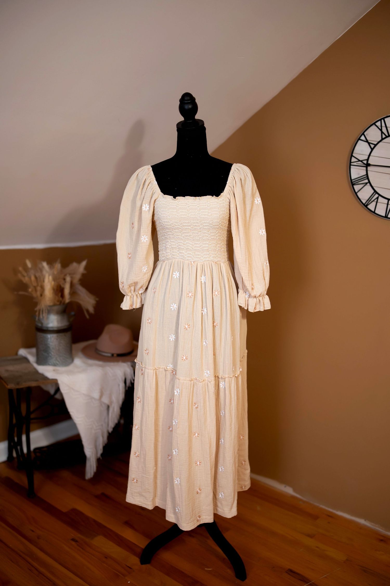 A vintage green Victorian-style dress displayed on a mannequin with off-shoulder sleeves and gathered fabric details.
