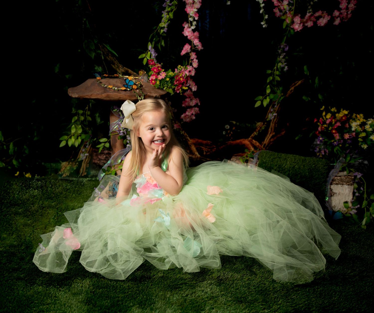 A sequence of photos shows a model in a mint green tulle gown posing gracefully among blooming cherry blossoms at night.