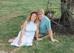 Casual outdoor photo session with people in coordinated blue and white clothing sitting on grass.