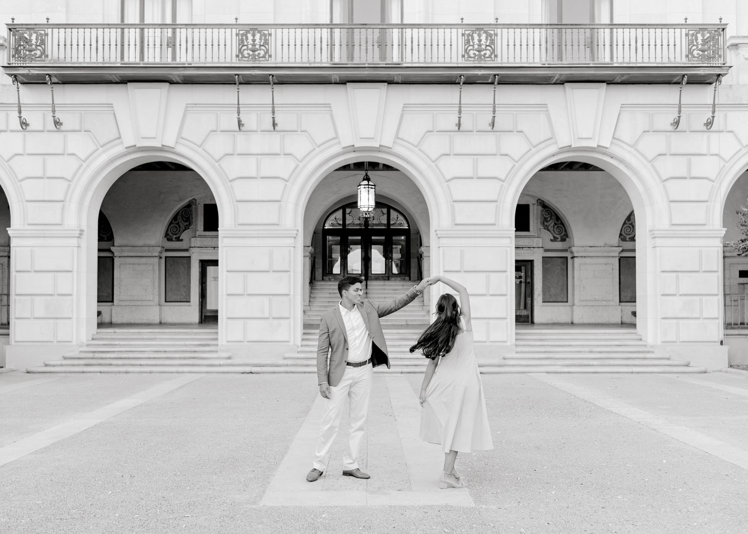 A series of black and white architectural photographs showing stone archways and columns in a classic building hallway.