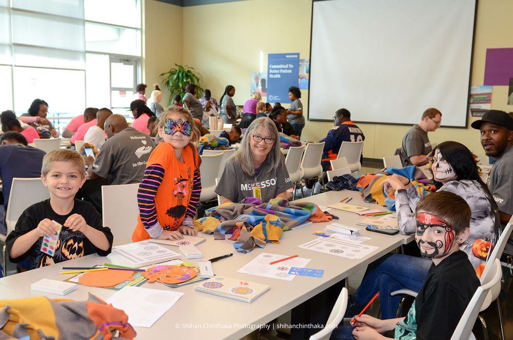 Students participate in classroom activities at tables with art supplies.