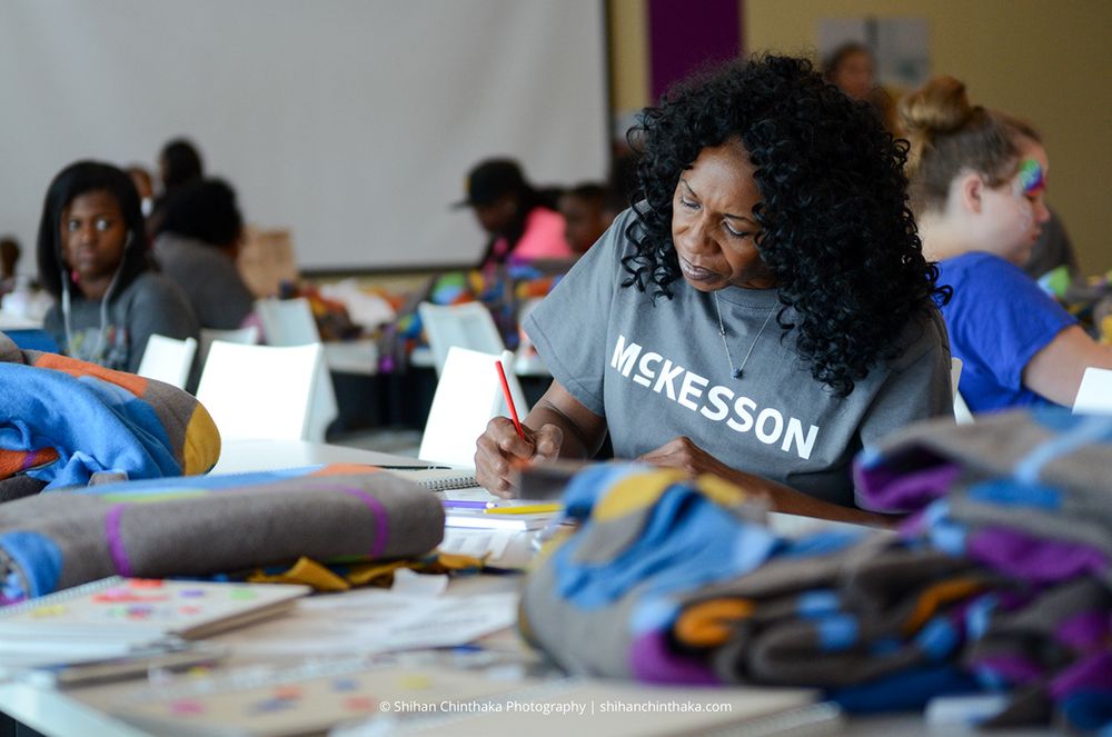 Participants working on crafts and activities at tables during community workshop.