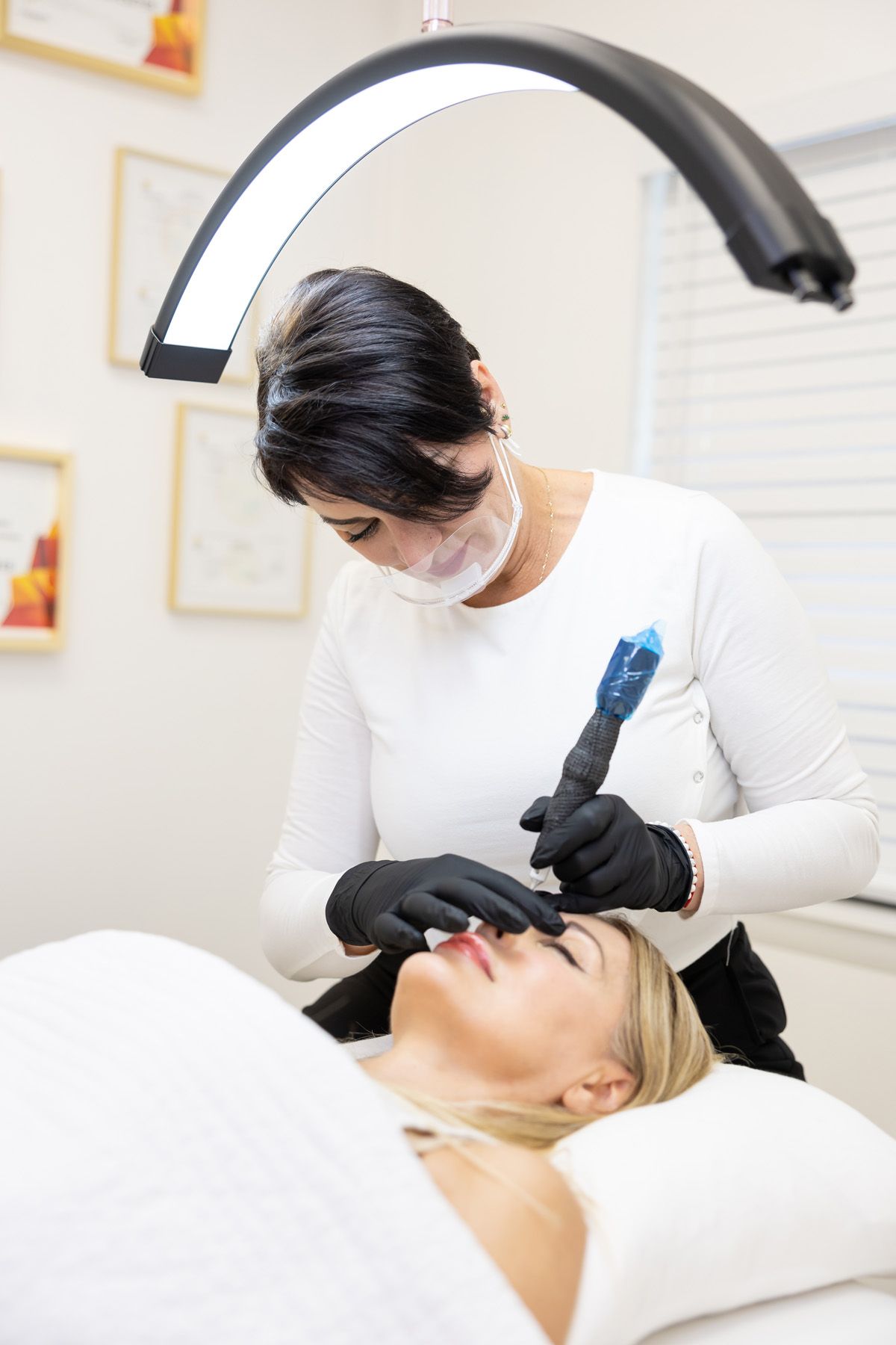 Professional esthetician performing a facial treatment on client using specialized skincare equipment.