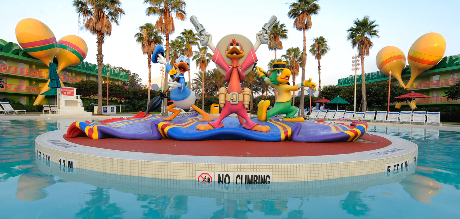 Vibrant pool area with giant decorative instruments and palm trees at Disney's All-Star Music Resort.