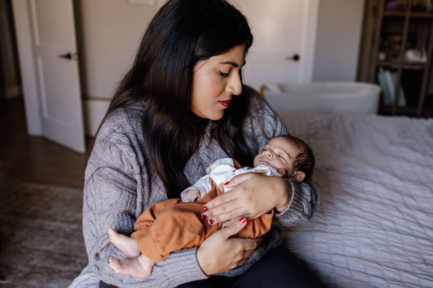 Mom cuddles new baby at San Jose in-home photography session