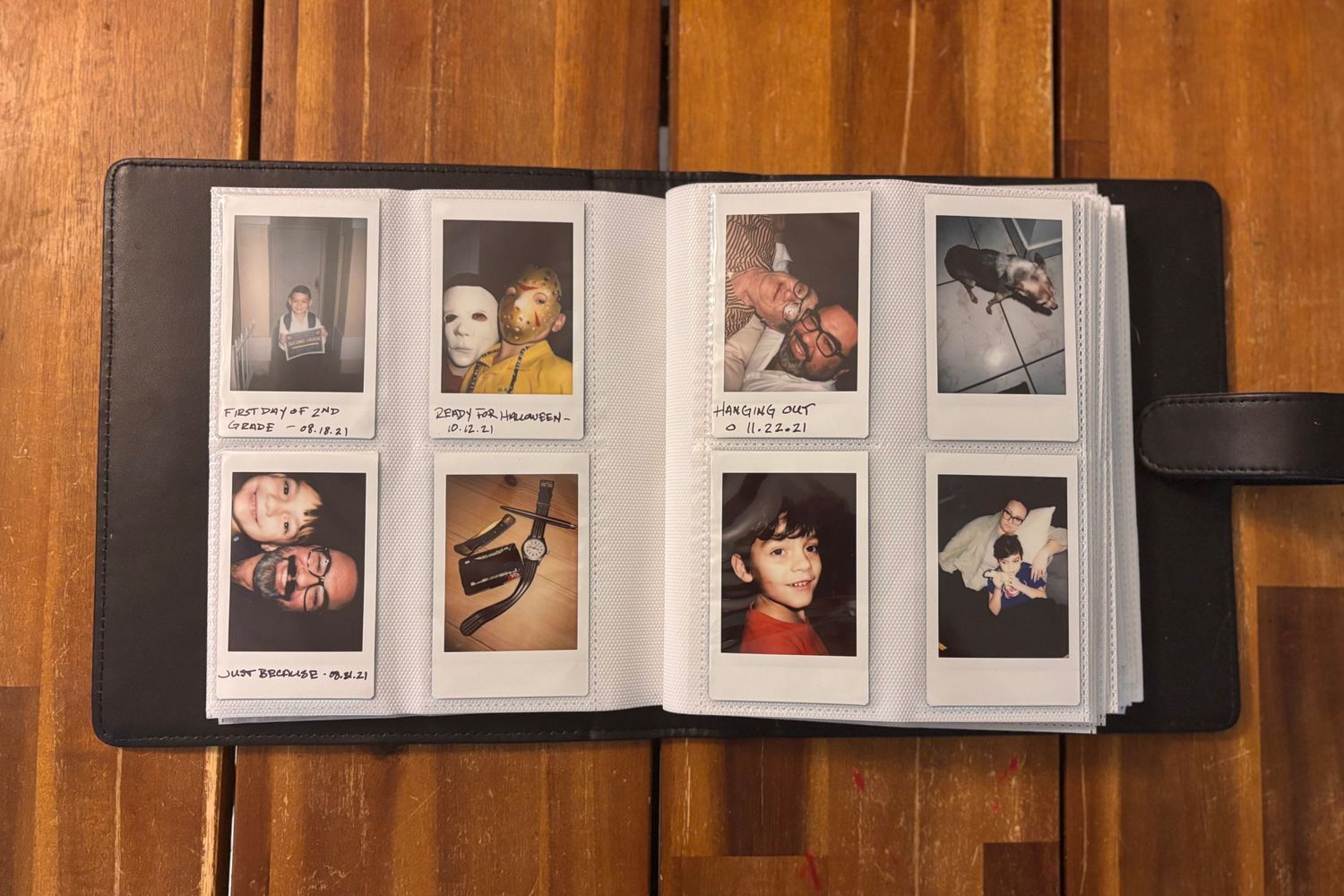 Open photo album with polaroid-style photographs arranged in neat grid layout.