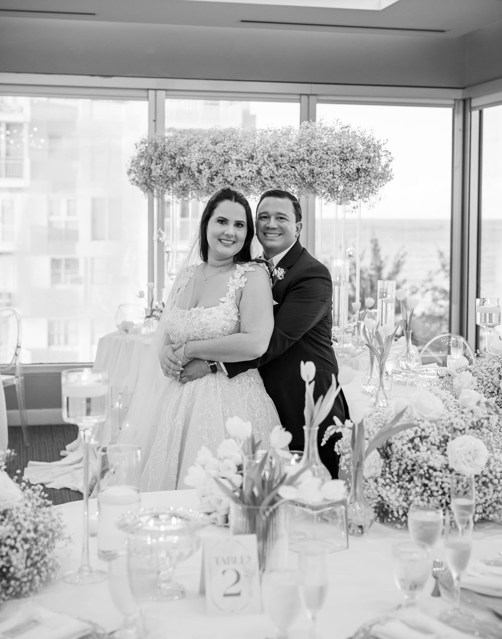 Black and white wedding photo with elegant table settings and suspended baby's breath centerpiece.