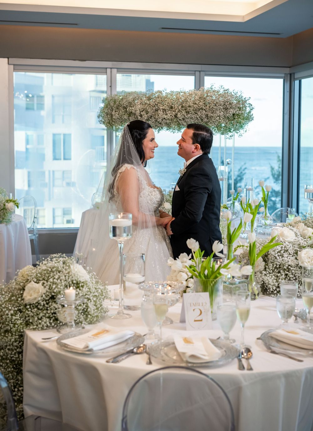 An elegant wedding reception with baby's breath arrangements and white table settings.