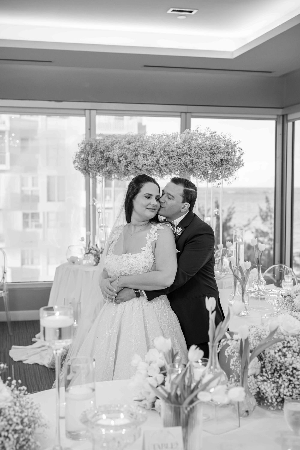 Black and white portrait of tender moment between couple at wedding reception.