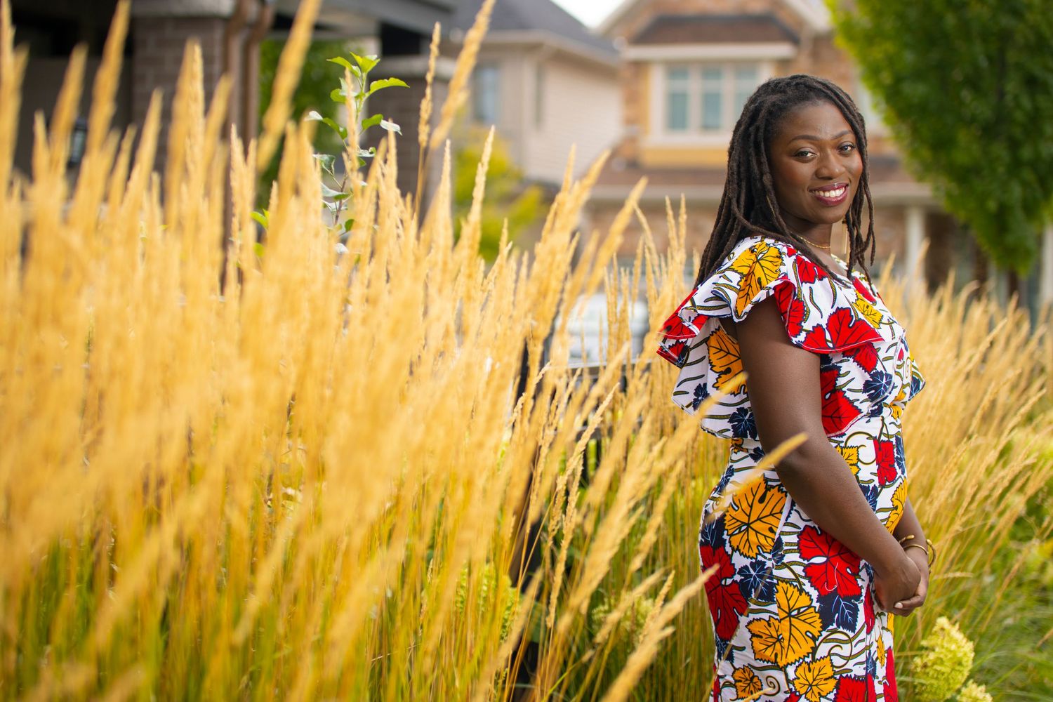 A colorful floral print dress stands out against golden wheat grass in a vibrant outdoor portrait.