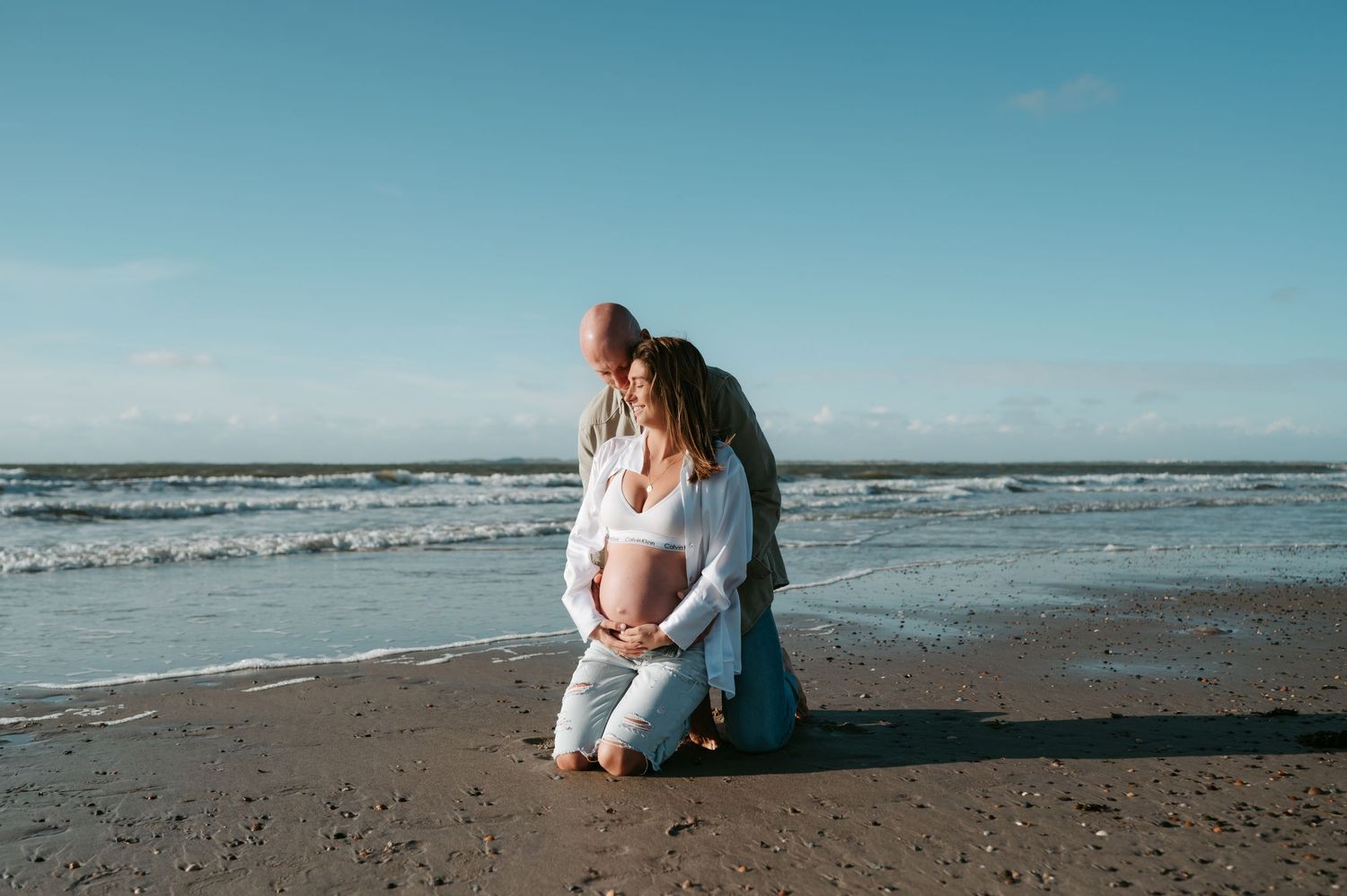 Melissa Stuer Photography Moederschapsfotograaf Moerbeke Zwangerschapsfotograaf zwangere vrouw en man zee strand koppel knuffelend