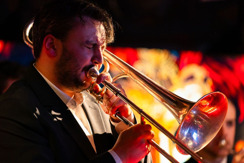 A trombone player performs on stage at a Christmas party.