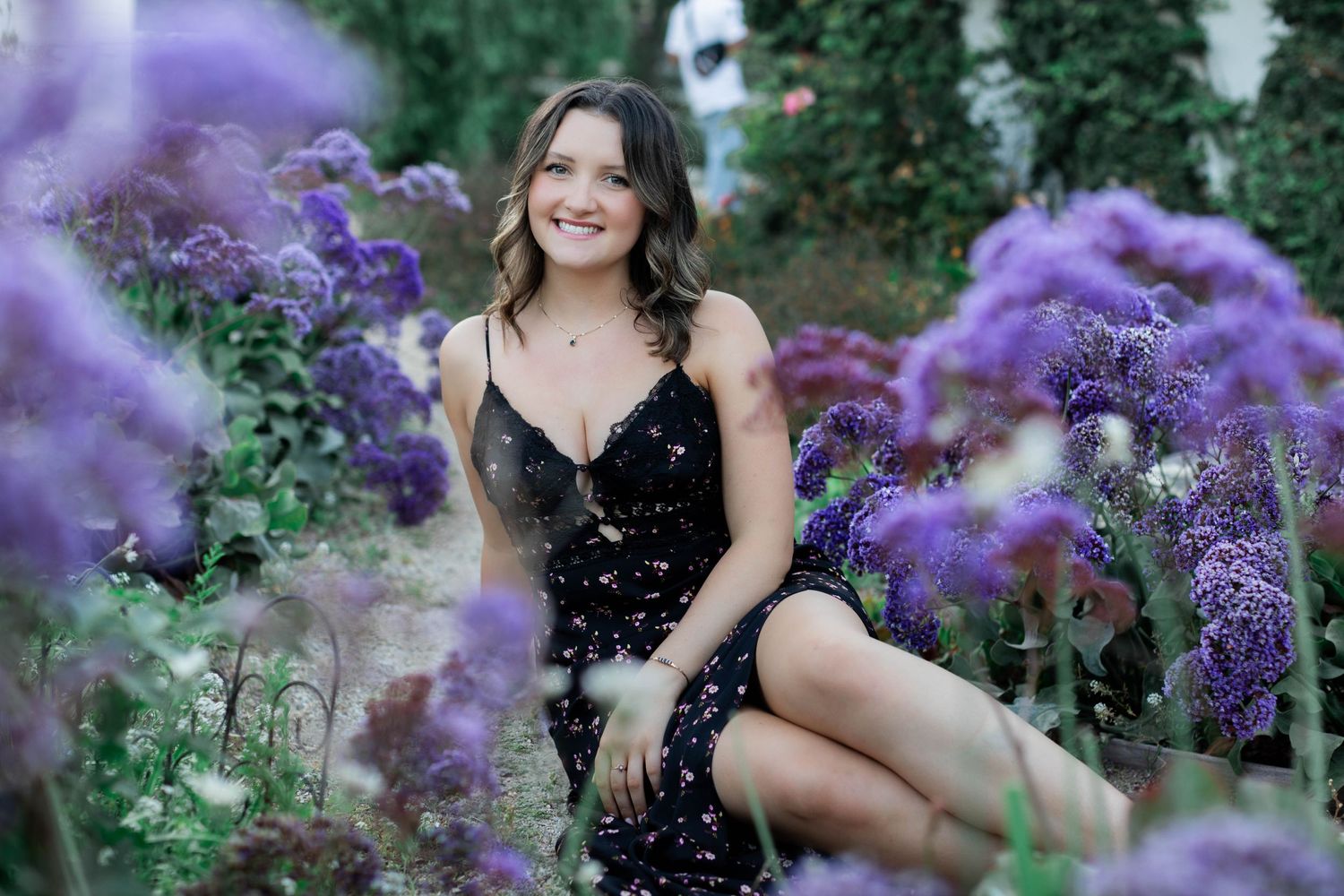 Portrait session among blooming purple flowers in garden setting.