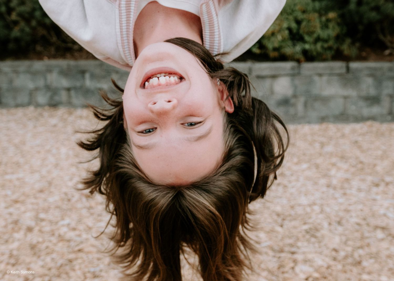 A playful upside down portrait against a textured background.