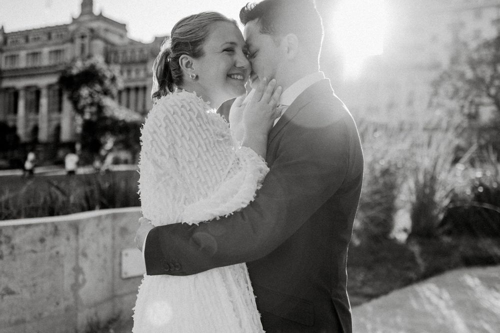 A romantic black and white wedding photo showing an intimate moment outdoors.