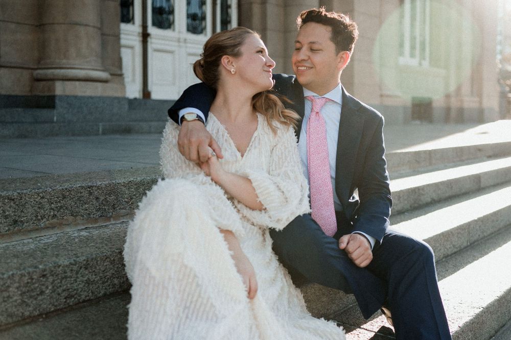 A tender moment captured on stone steps with sunlight streaming through.