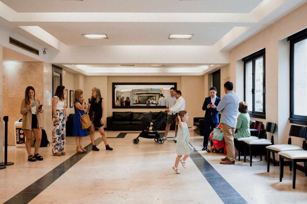 People gather in a modern lobby area with sleek furnishings and lighting.