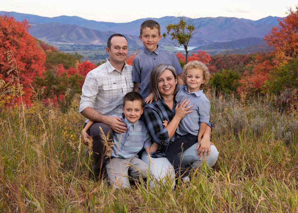 Family enjoying a scenic autumn mountain view with colorful fall foliage in the background.