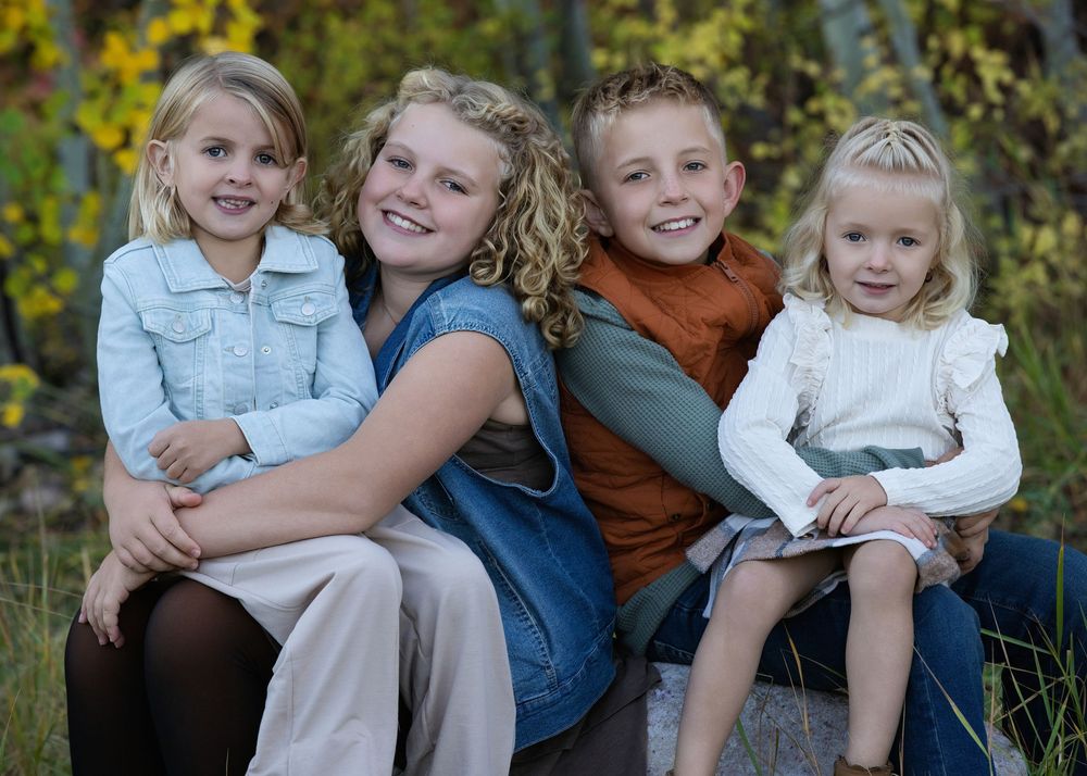 A series of outdoor family portrait photos showing joyful interactions and natural poses against a wooded backdrop.