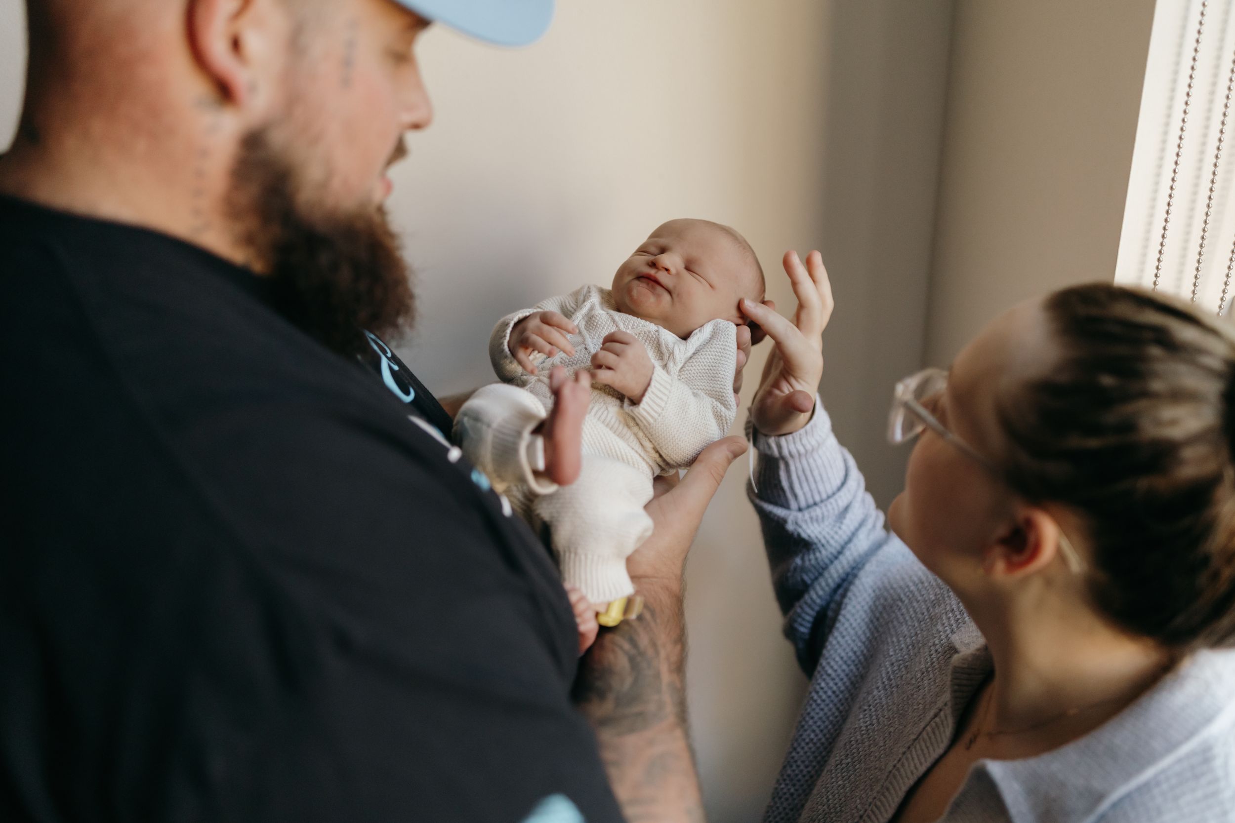 Parents holding and gazing at their newborn baby together. Virginia/ North Carolina Newborn First 48 Hours Session