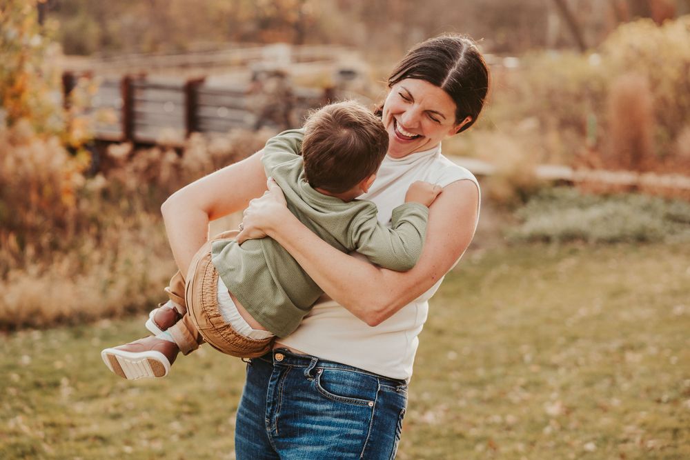 Playful moment captured between parent and child in autumn setting.