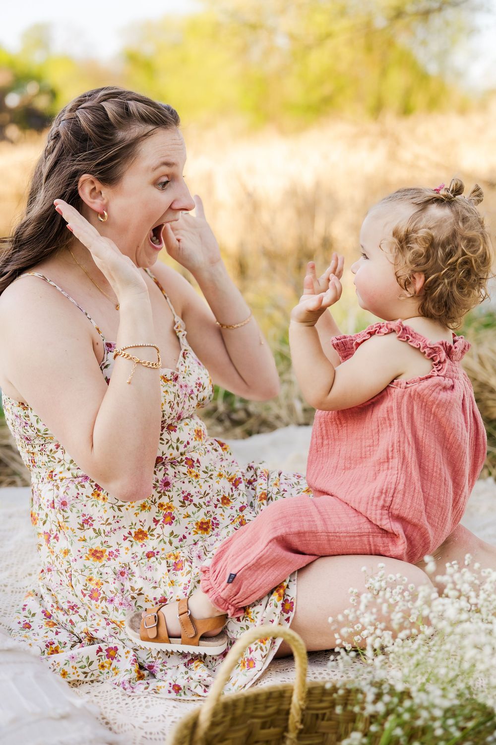 A joyful outdoor moment captured in a field of wildflowers with floral and pink sundresses on a sunny day.