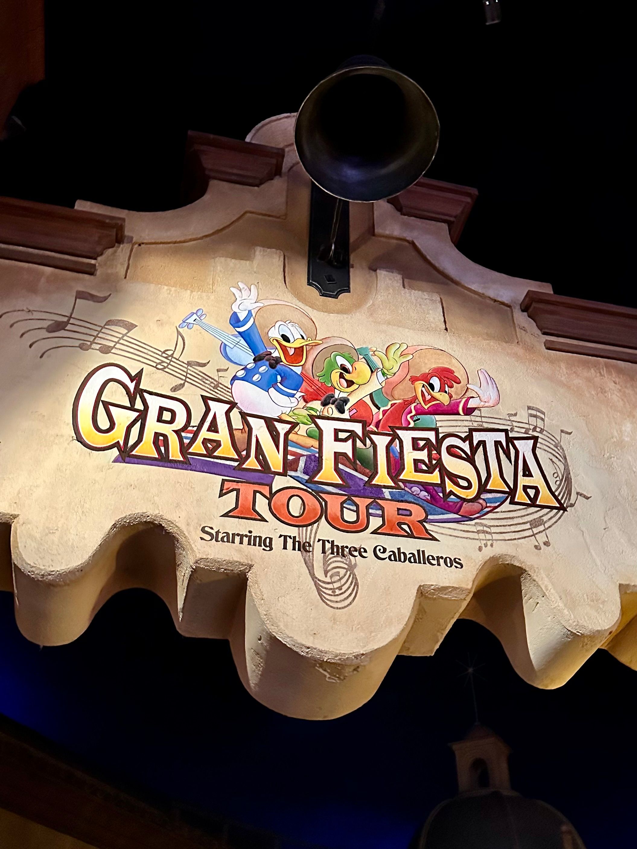 Close-up view of illuminated Gran Fiesta Tour Starring The Three Caballeros attraction sign at Disney World.