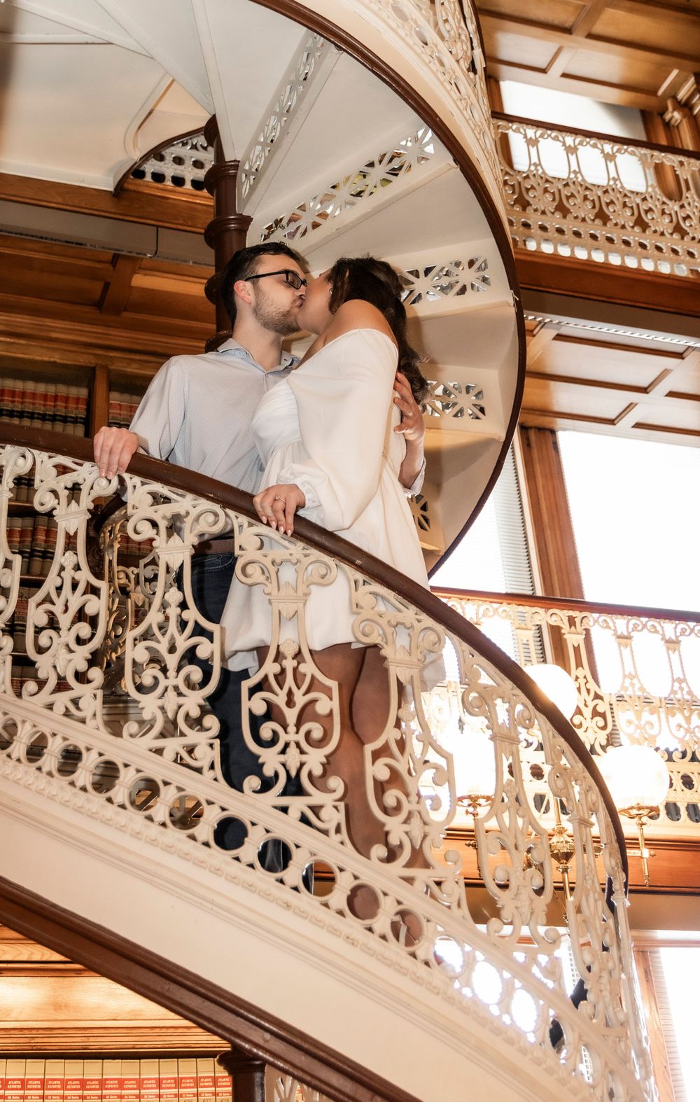 Couple standing on the staircase inside the Library at the Iowa State Capital Building.