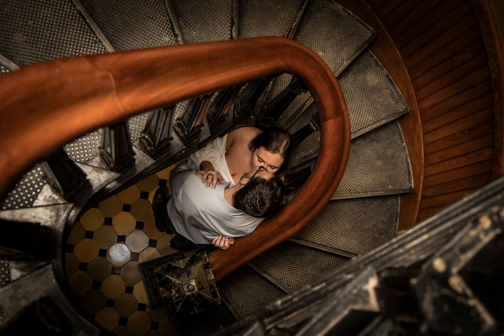 Couple hugging inside small staircase at the Iowa State Capital Building.