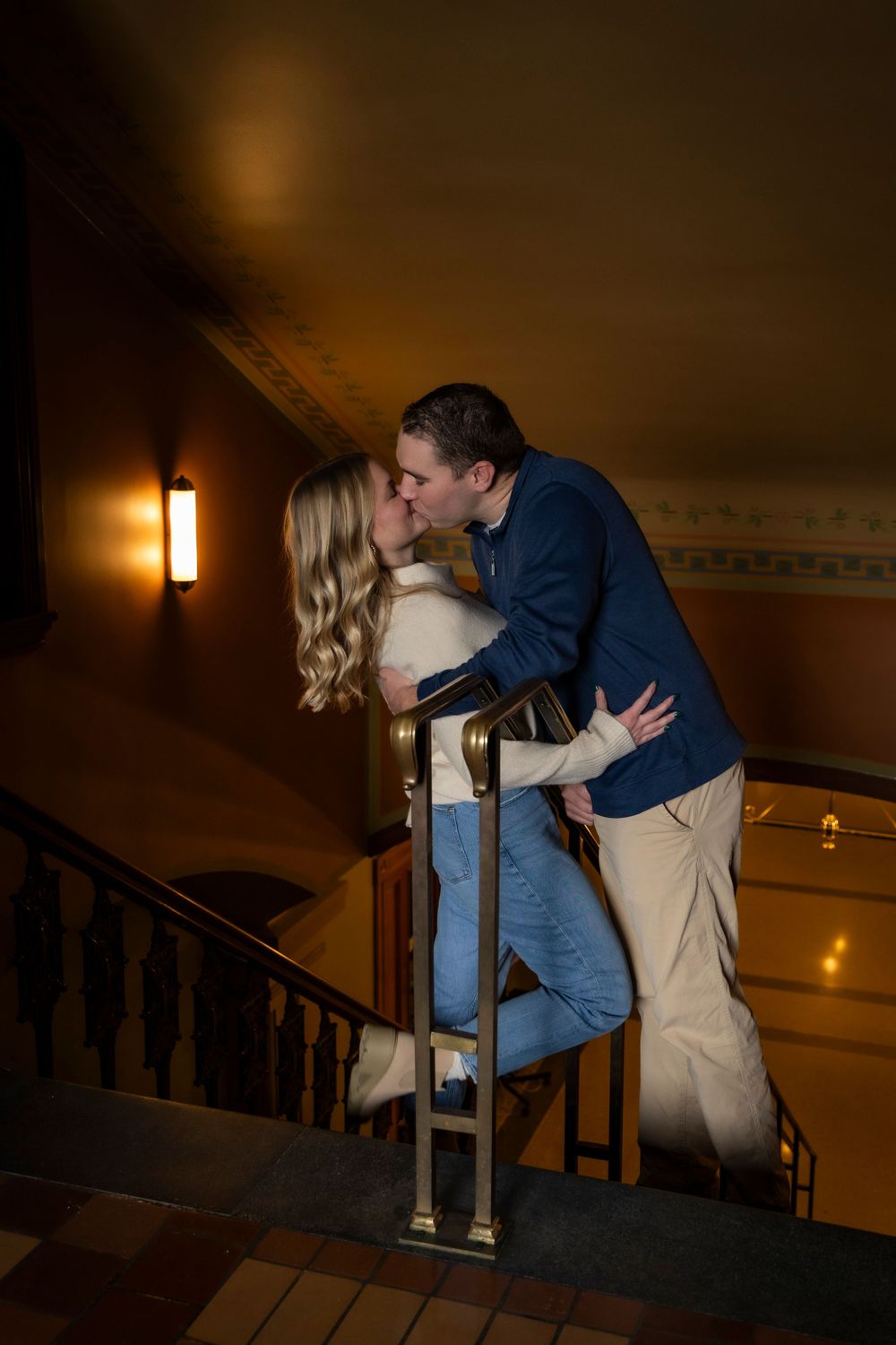 Couple kissing on stair steps down to the lower level at the Iowa State Capital.