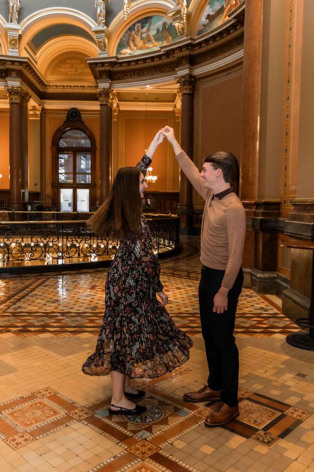 Man spinning his fiancé inside the Iowa State Capital Building.