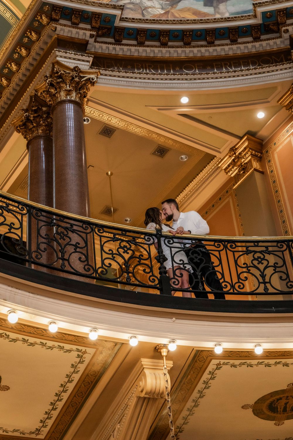 Couple on 2nd floor balcony at the Iowa State Capital Building during their engagement session.