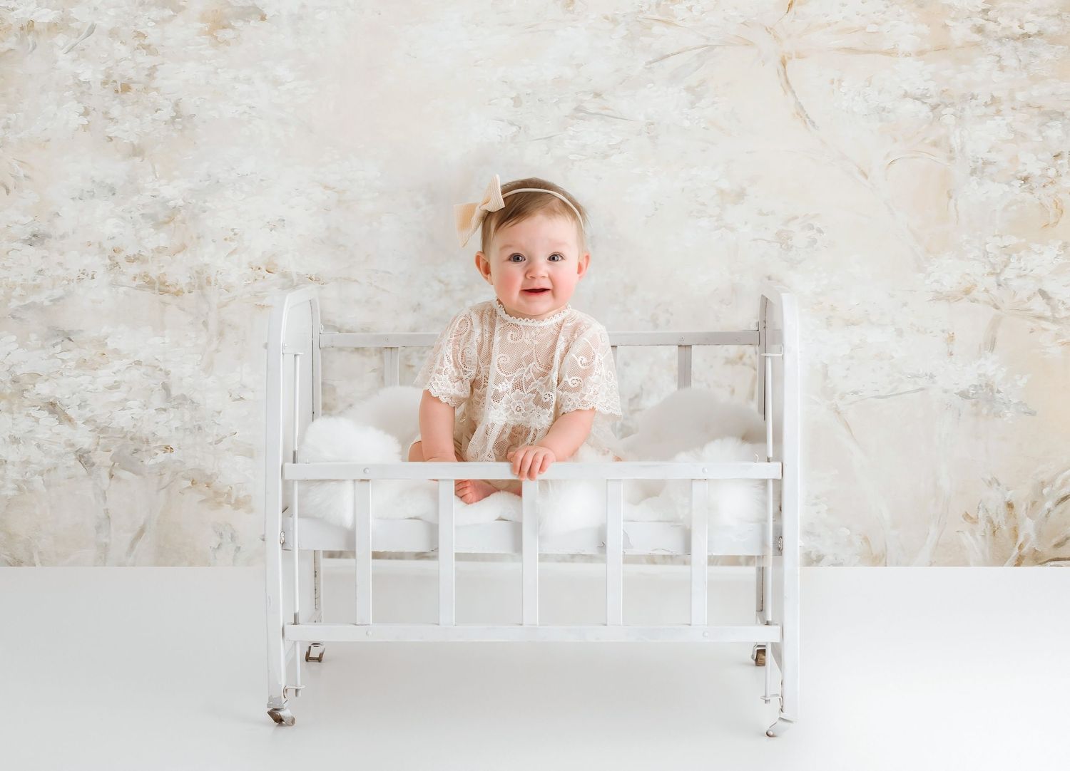 White vintage-style crib with textured neutral wall background.
