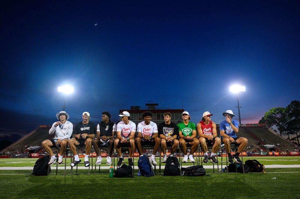 A panoramic sequence of a sports field at night with stadium lights illuminating the playing surface and sidelines.