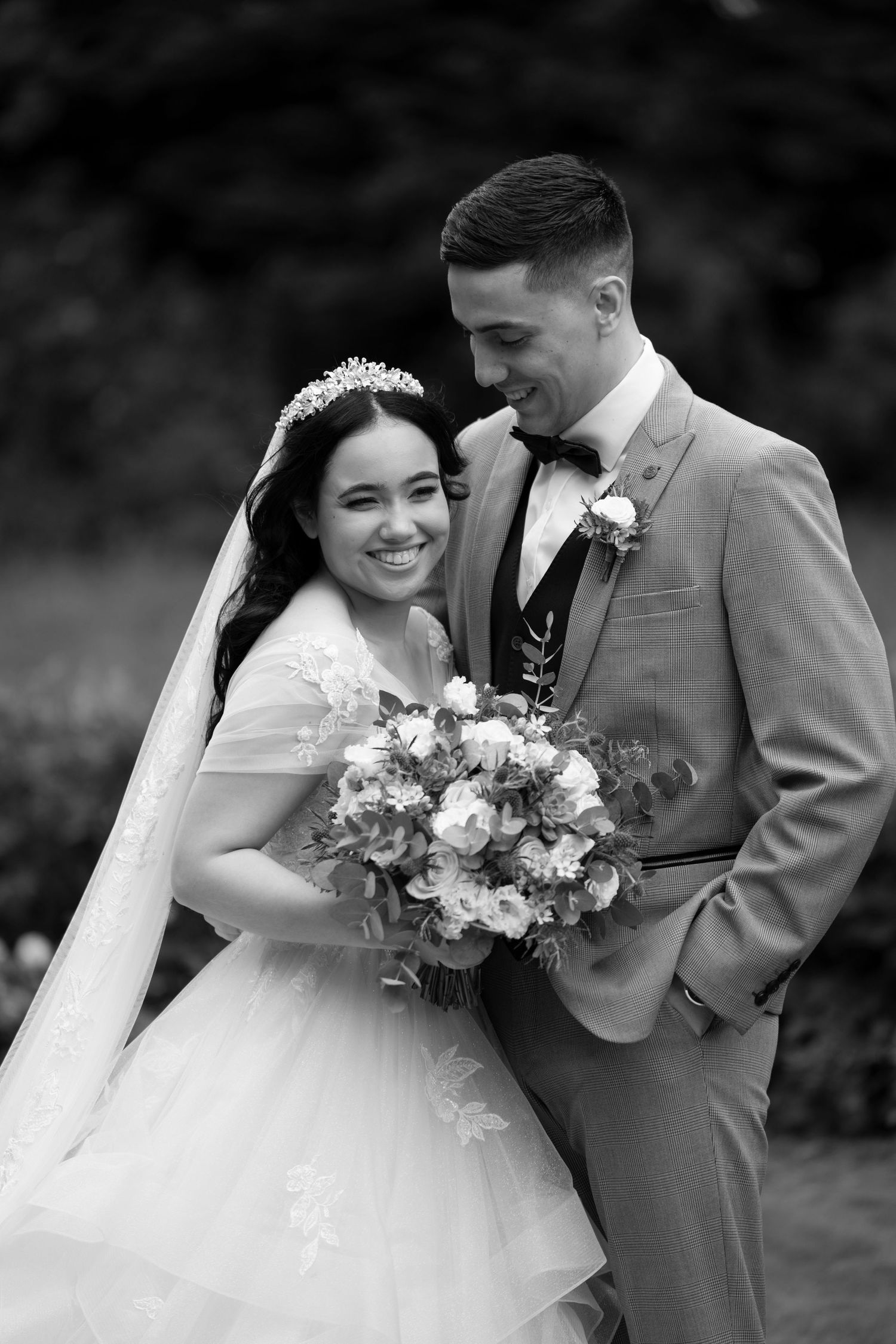A tender black and white wedding portrait capturing an intimate moment between newlyweds.
