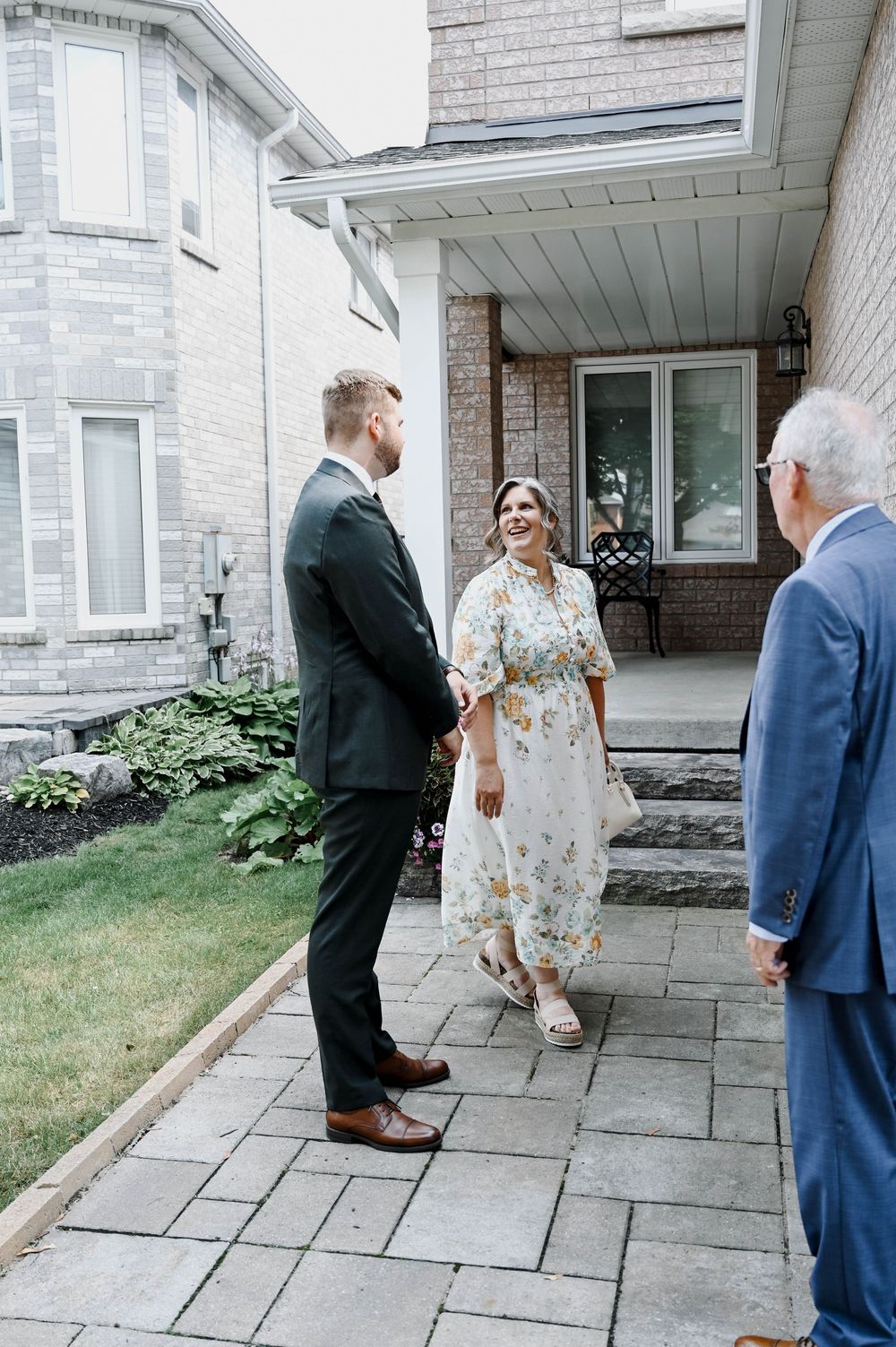 A sequence of candid wedding party moments outside a stone building, showing interactions on a paved walkway.