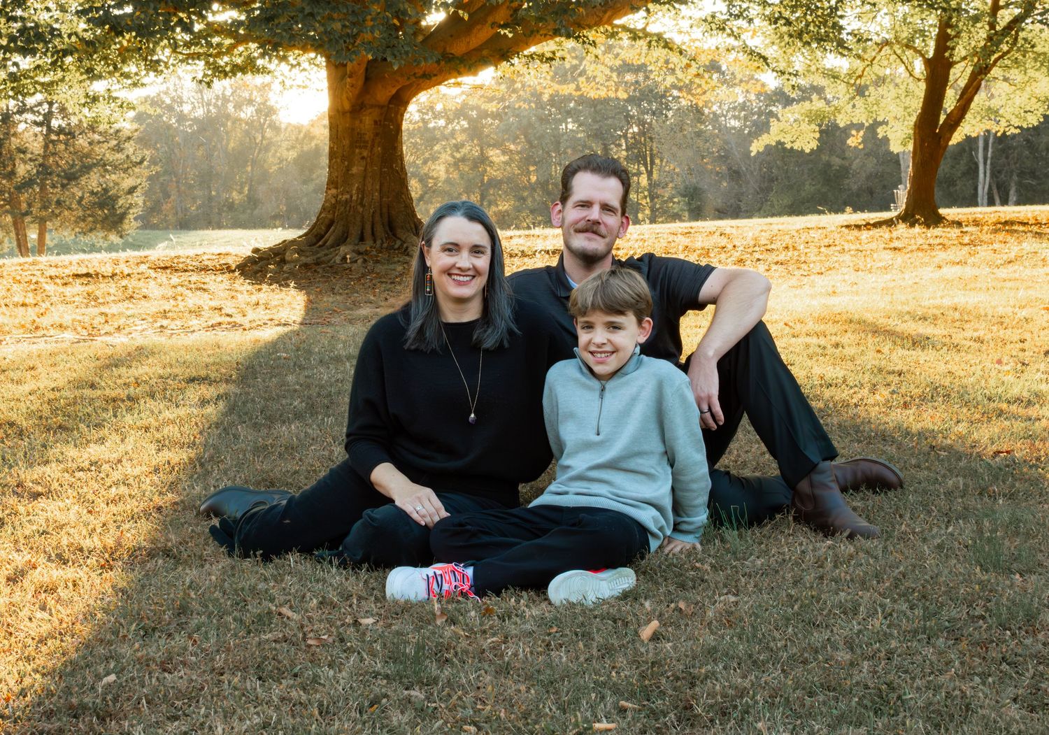 family posed on grass field for a family photo session