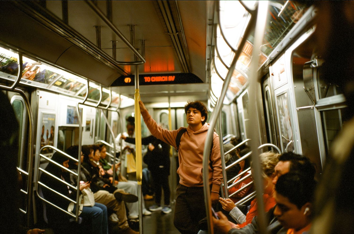 Crowded New York City subway car interior with passengers during evening commute.