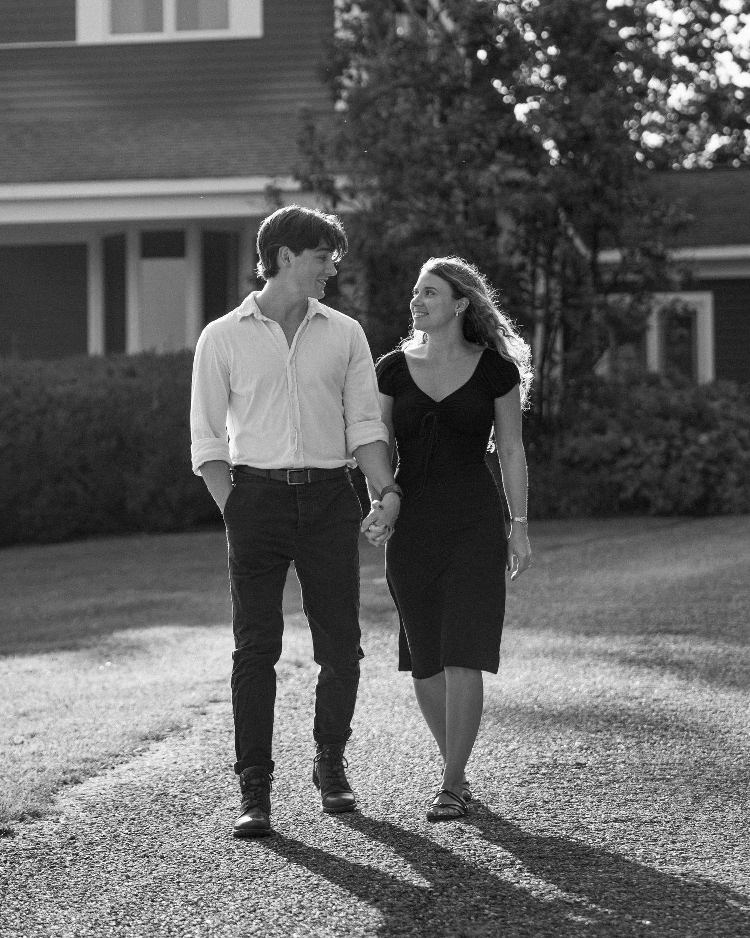 People walking on gravel path in black and white formal attire.